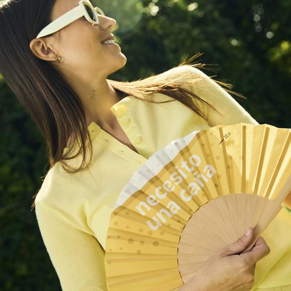 Persona usando abanico Necesito una Caña en terraza de verano